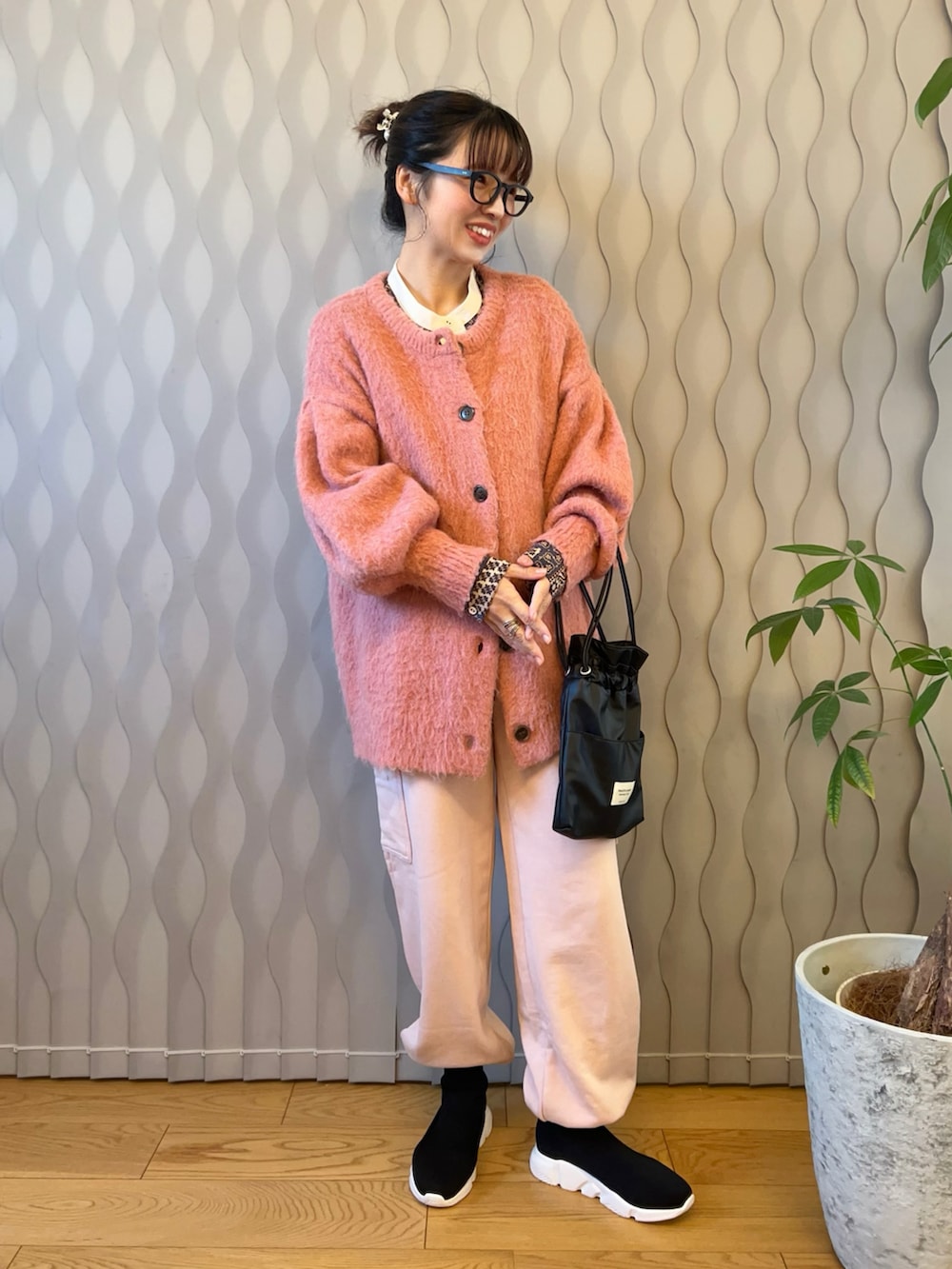 ピンク系のカーディガン/ボレロ、ブルー系のシャツ/ブラウス、ブラック系のショルダーバッグを着用したレディースの冬コーディネートの2枚目の写真