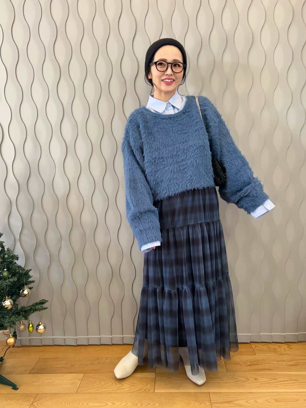 ブルー系のニット/セーター、ブルー系のシャツ/ブラウス、ブルー系のスカートを着用したレディースの冬コーディネートの2枚目の写真
