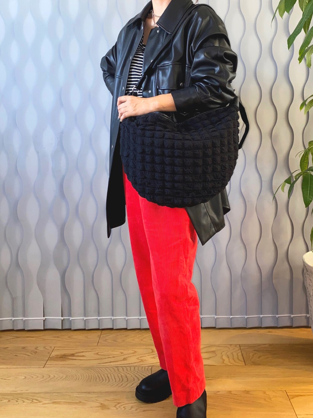 ブラック系のジャケット/アウター、ブラック系のTシャツ/カットソー、ブラック系のメッセンジャーバッグを着用したレディースの秋コーディネートの2枚目の写真