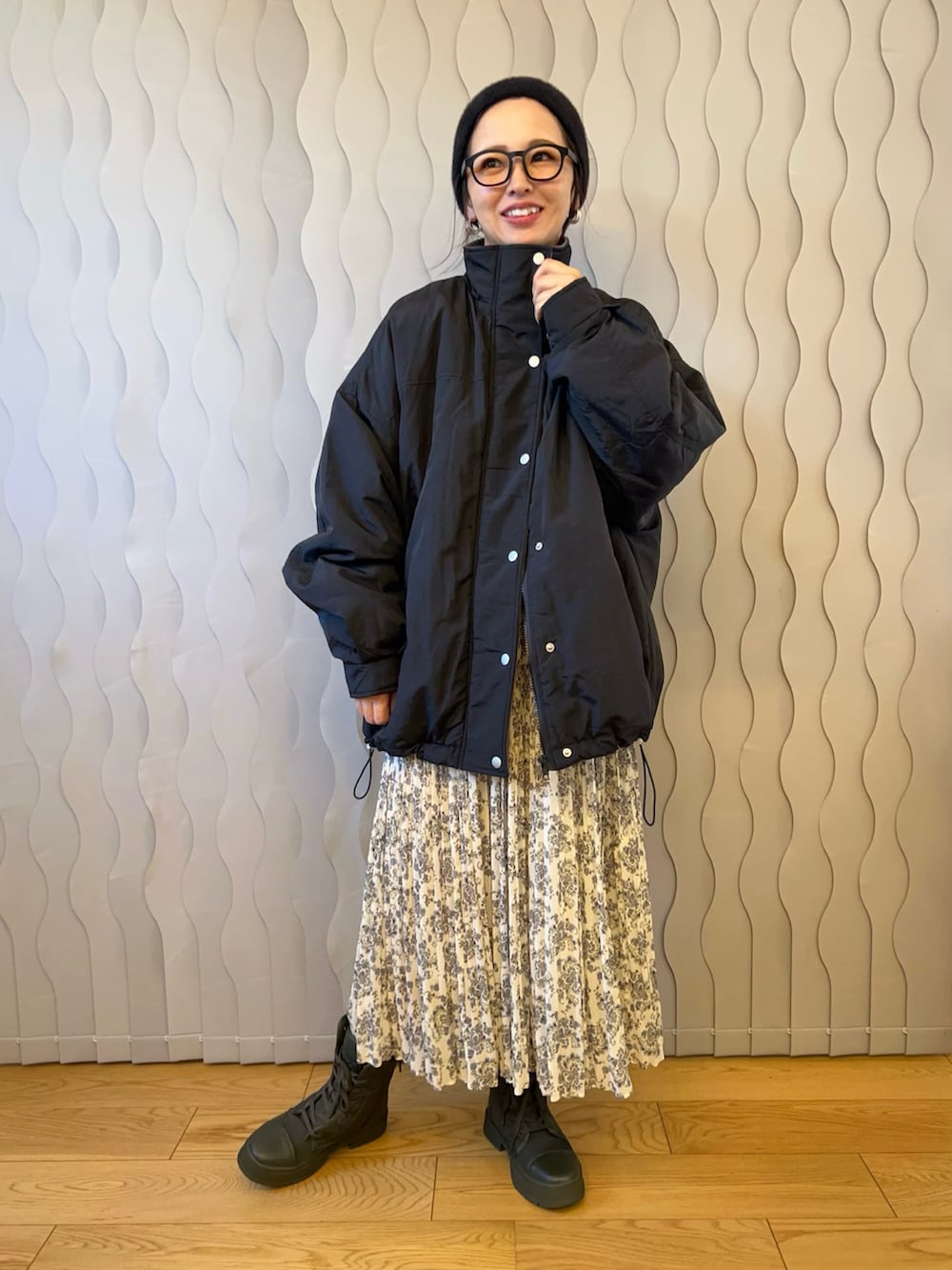 ブラック系のブルゾン、ホワイト系のワンピース、グリーン系のスニーカーを着用したレディースの秋コーディネートの2枚目の写真