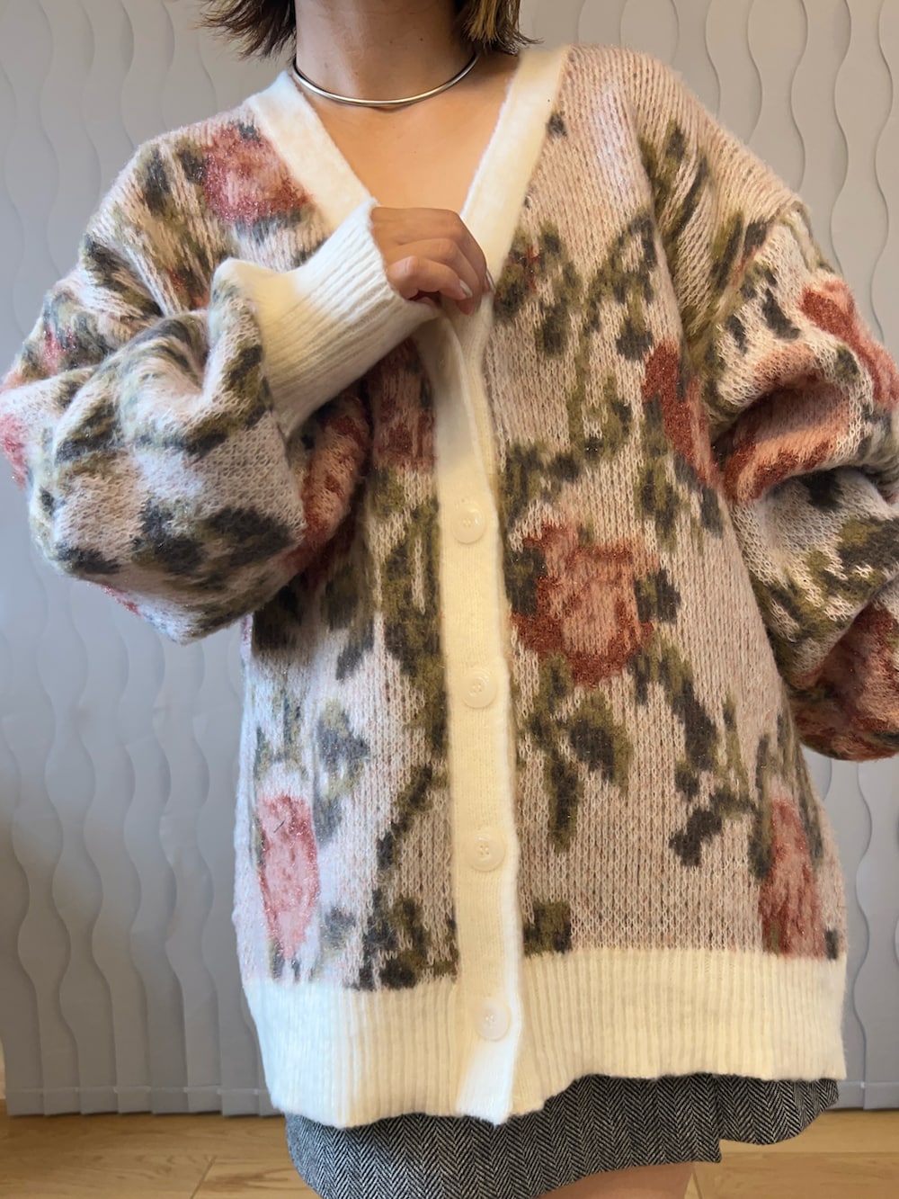 ホワイト系のカーディガン/ボレロ、グレー系のスカート、ブラック系のブーツを着用したレディースの秋コーディネートの3枚目の写真