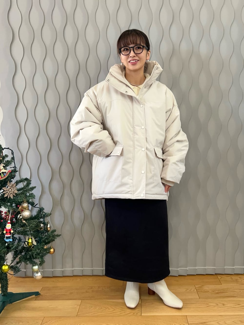 ホワイト系のブルゾン、ホワイト系のブーツ、ブラック系のスカートを着用したレディースの冬コーディネートの3枚目の写真