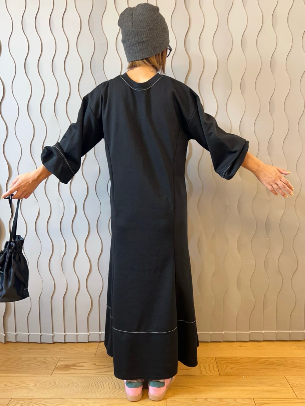 ブラック系のワンピース、ピンク系のスニーカー、シルバー系のチョーカーを着用したレディースの秋コーディネートの2枚目の写真