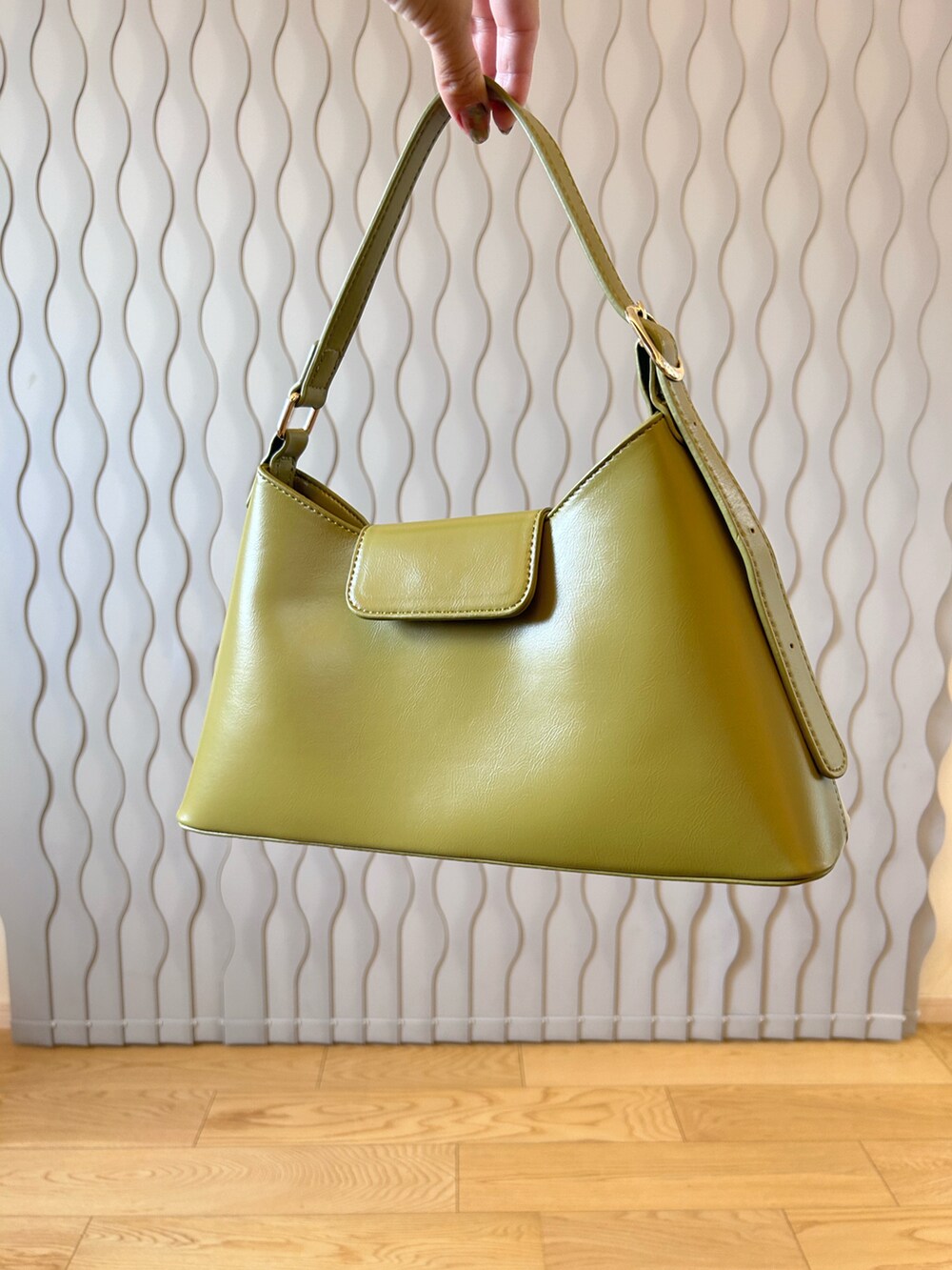 グリーン系のハンドバッグ、ブラック系のサンダル、ホワイト系のTシャツ/カットソーを着用したレディースの夏コーディネートの2枚目の写真