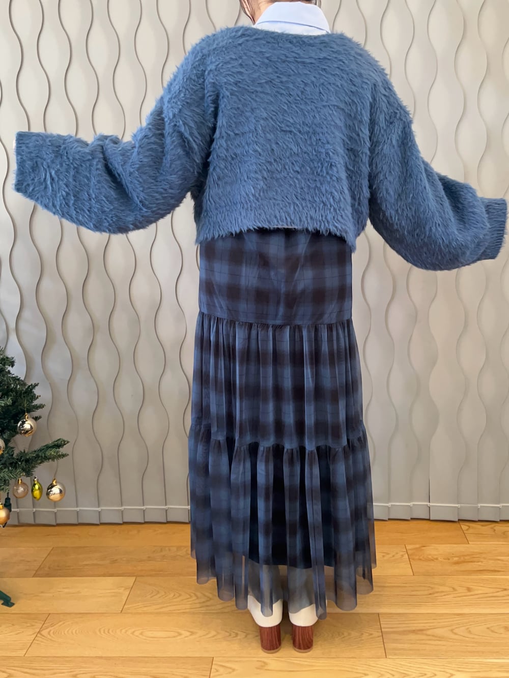 ブルー系のニット/セーター、ブルー系のシャツ/ブラウス、ブルー系のスカートを着用したレディースの冬コーディネートの3枚目の写真