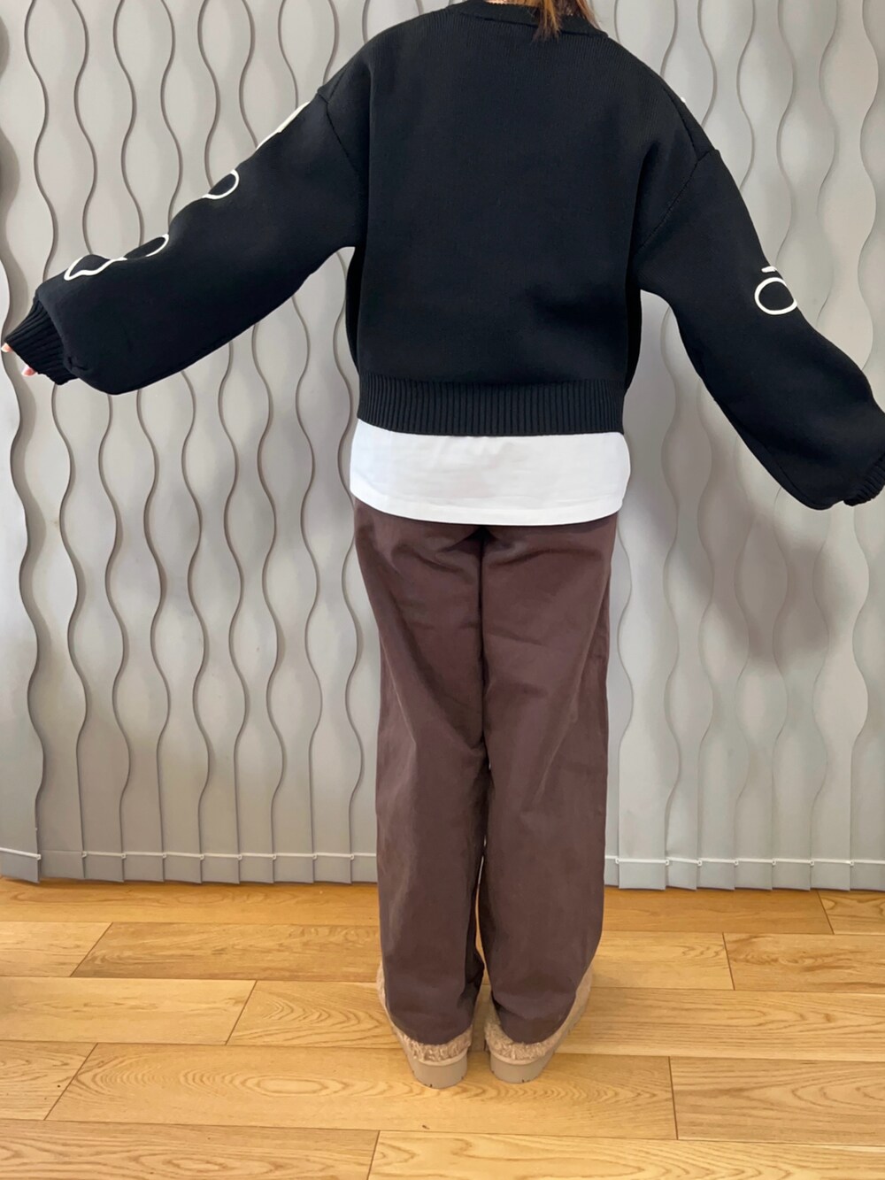 ブラック系のニット/セーター、ブラウン系のデニムパンツ、ベージュ系のスリッポンを着用したレディースの冬コーディネートの2枚目の写真