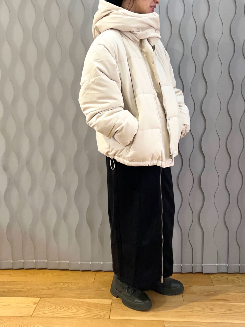 ホワイト系のダウンジャケット/コート、ブラック系のスカート、グリーン系のスニーカーを着用したレディースの冬コーディネートの2枚目の写真