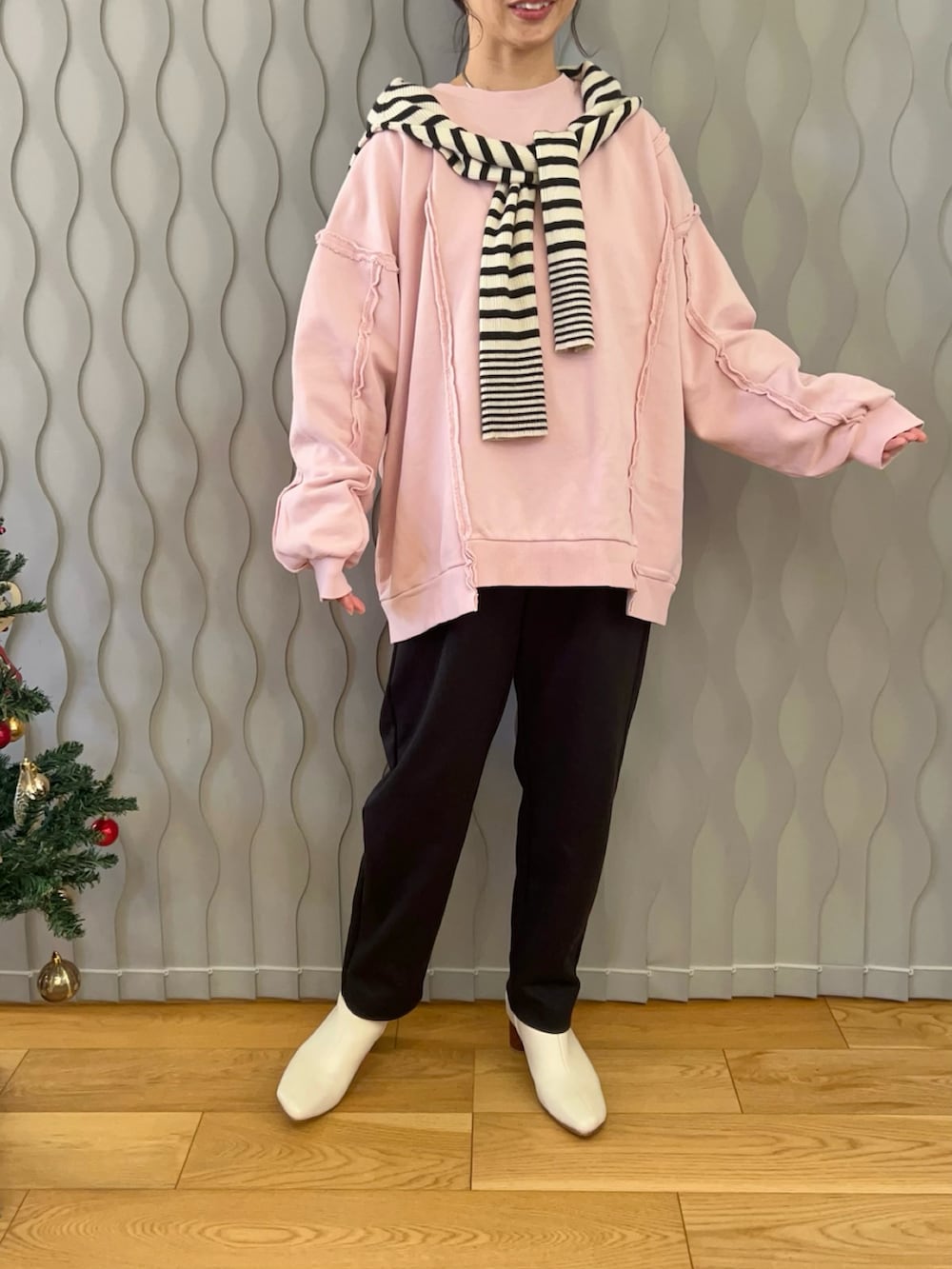 ホワイト系のニット/セーター、ピンク系のスウェット、ブラック系のパンツを着用したレディースの冬コーディネートの3枚目の写真