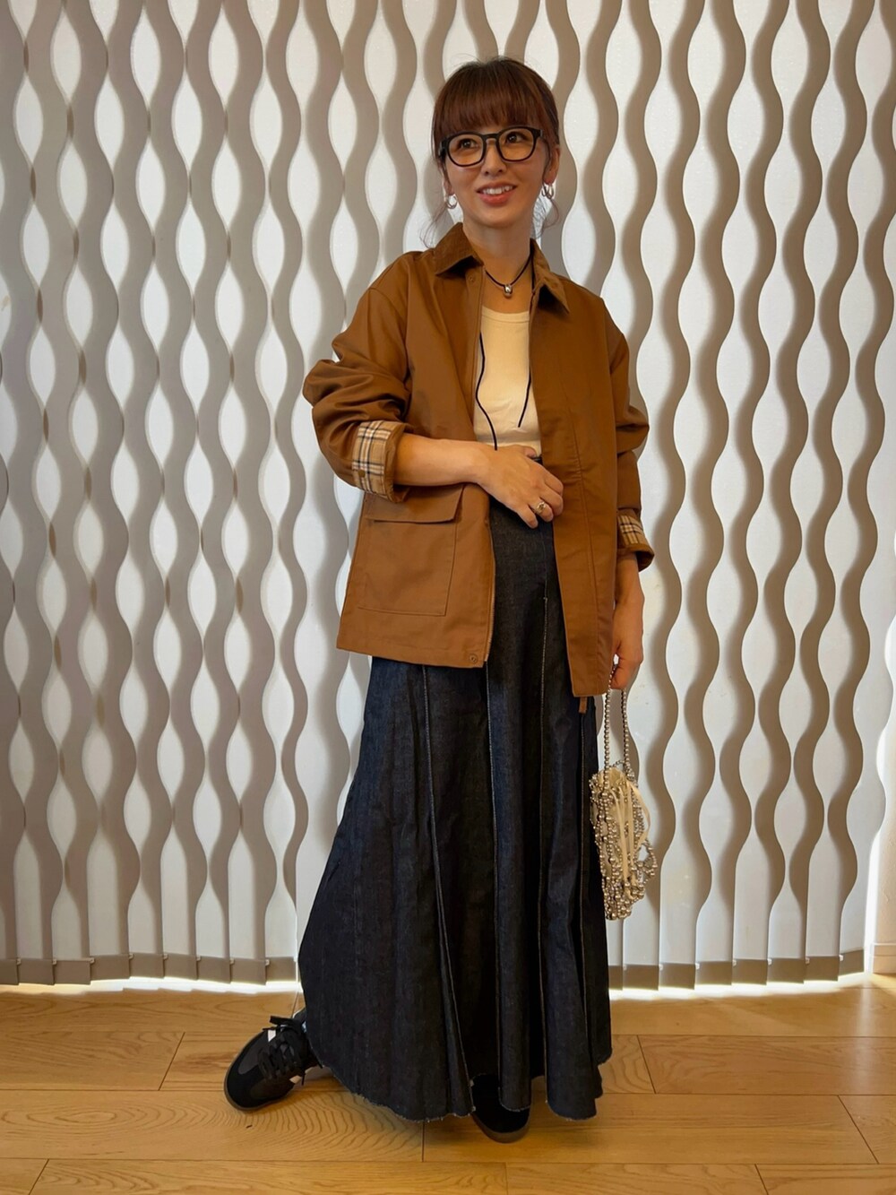 ブラウン系のジャケット/アウター、シルバー系のショルダーバッグ、ブルー系のデニムスカートを着用したレディースの夏コーディネートの2枚目の写真