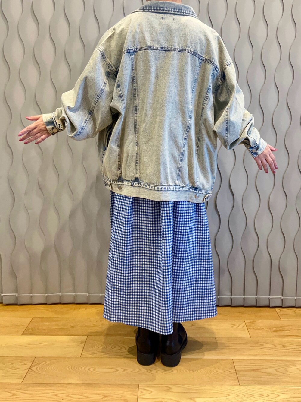 ブルー系のデニムジャケット、ブラック系のヘアバンドを着用したレディースの春コーディネートの2枚目の写真