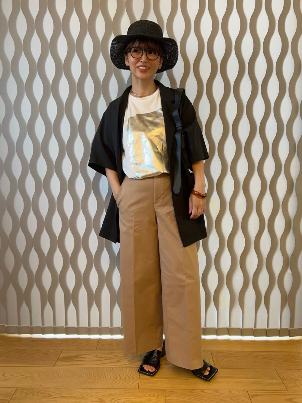 ホワイト系のTシャツ/カットソー、ブラック系のテーラードジャケット、ベージュ系のチノパンツを着用したレディースの夏コーディネートの2枚目の写真