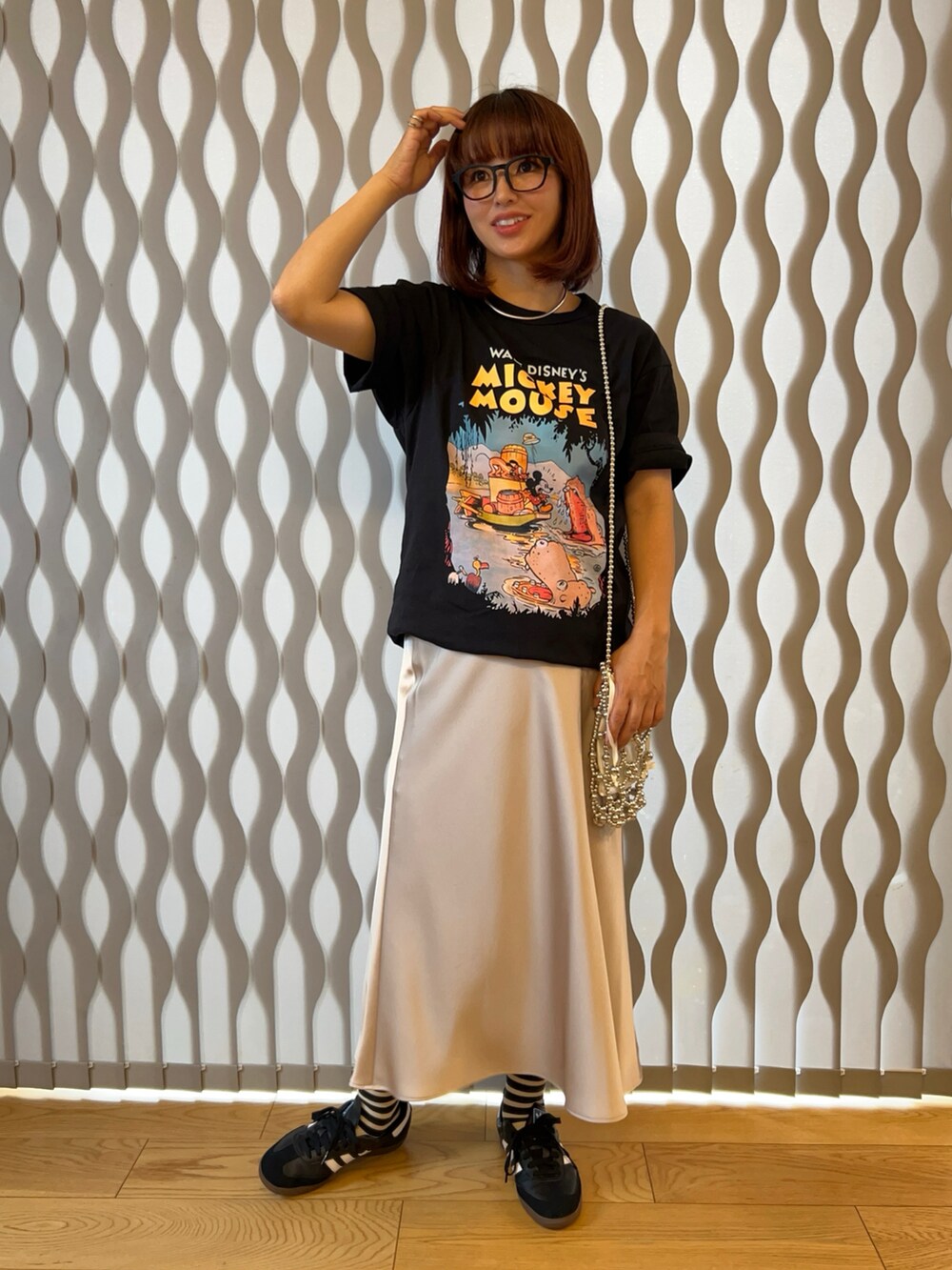 ブラック系のTシャツ/カットソー、シルバー系のショルダーバッグ、ベージュ系のスカートを着用したレディースの夏コーディネートの2枚目の写真