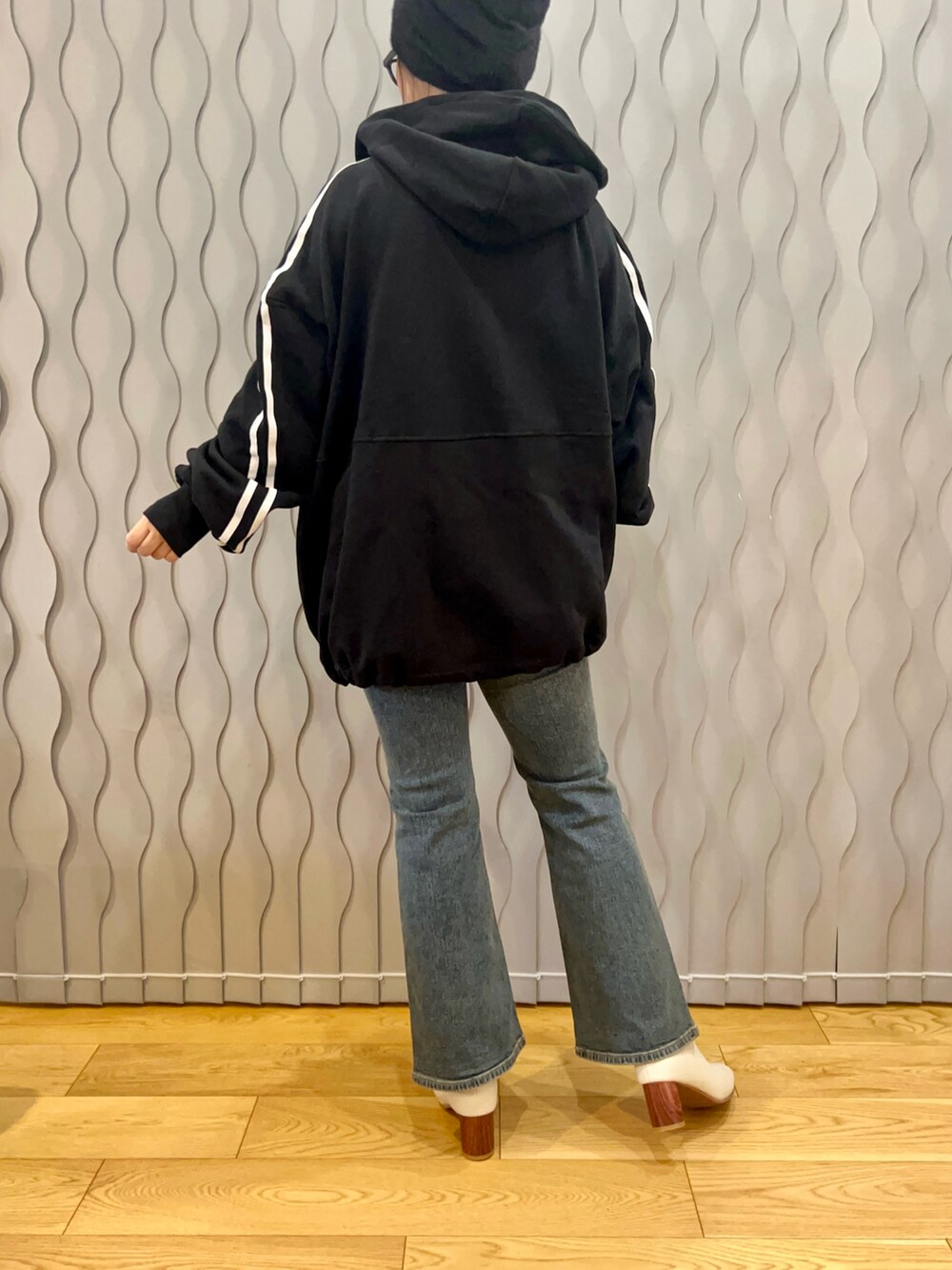 ブラック系のパーカー、ブルー系のデニムパンツ、ホワイト系のブーツを着用したレディースの冬コーディネートの2枚目の写真