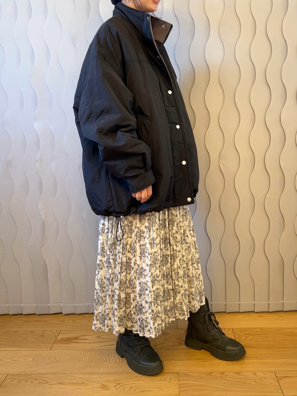 ブラック系のブルゾン、ホワイト系のワンピース、グリーン系のスニーカーを着用したレディースの秋コーディネートの3枚目の写真