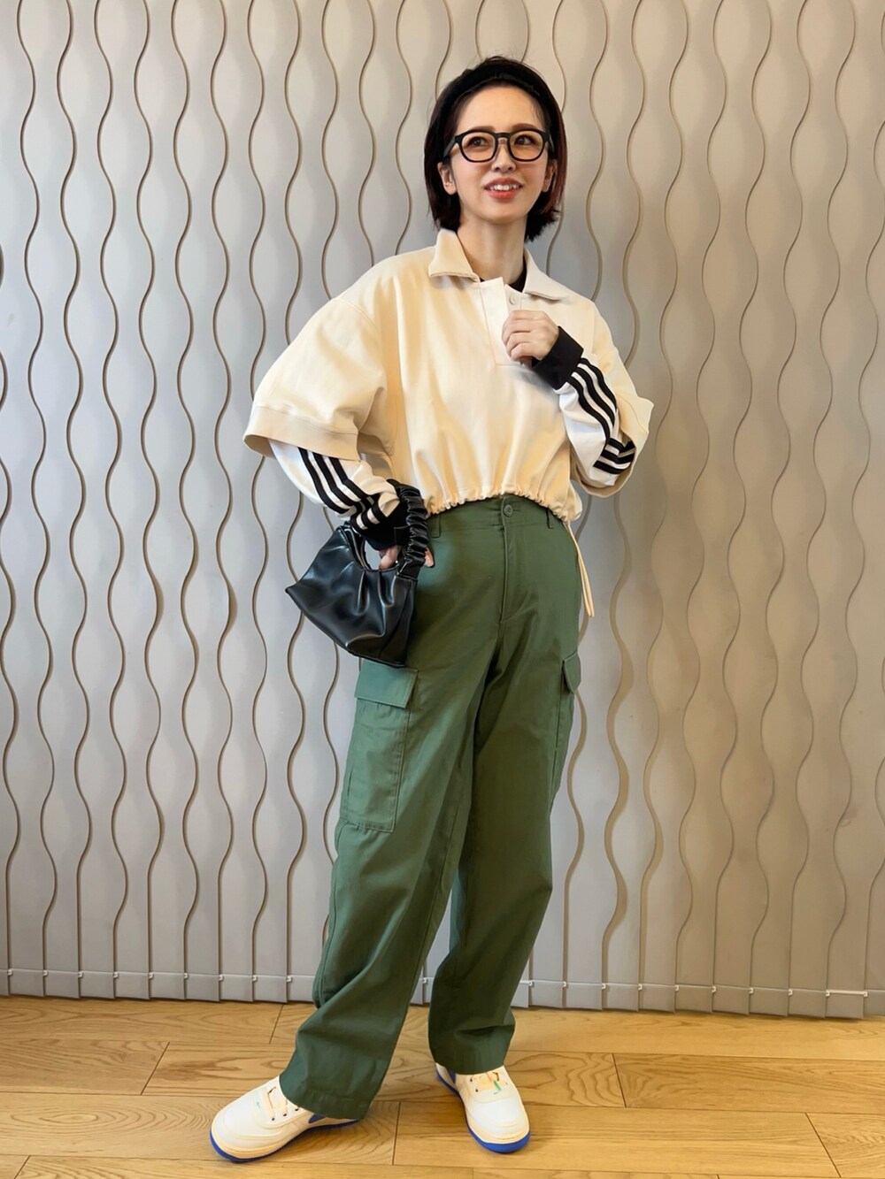 ホワイト系のポロシャツ、ホワイト系のTシャツ/カットソー、グリーン系のカーゴパンツを着用したレディースの冬コーディネートの2枚目の写真