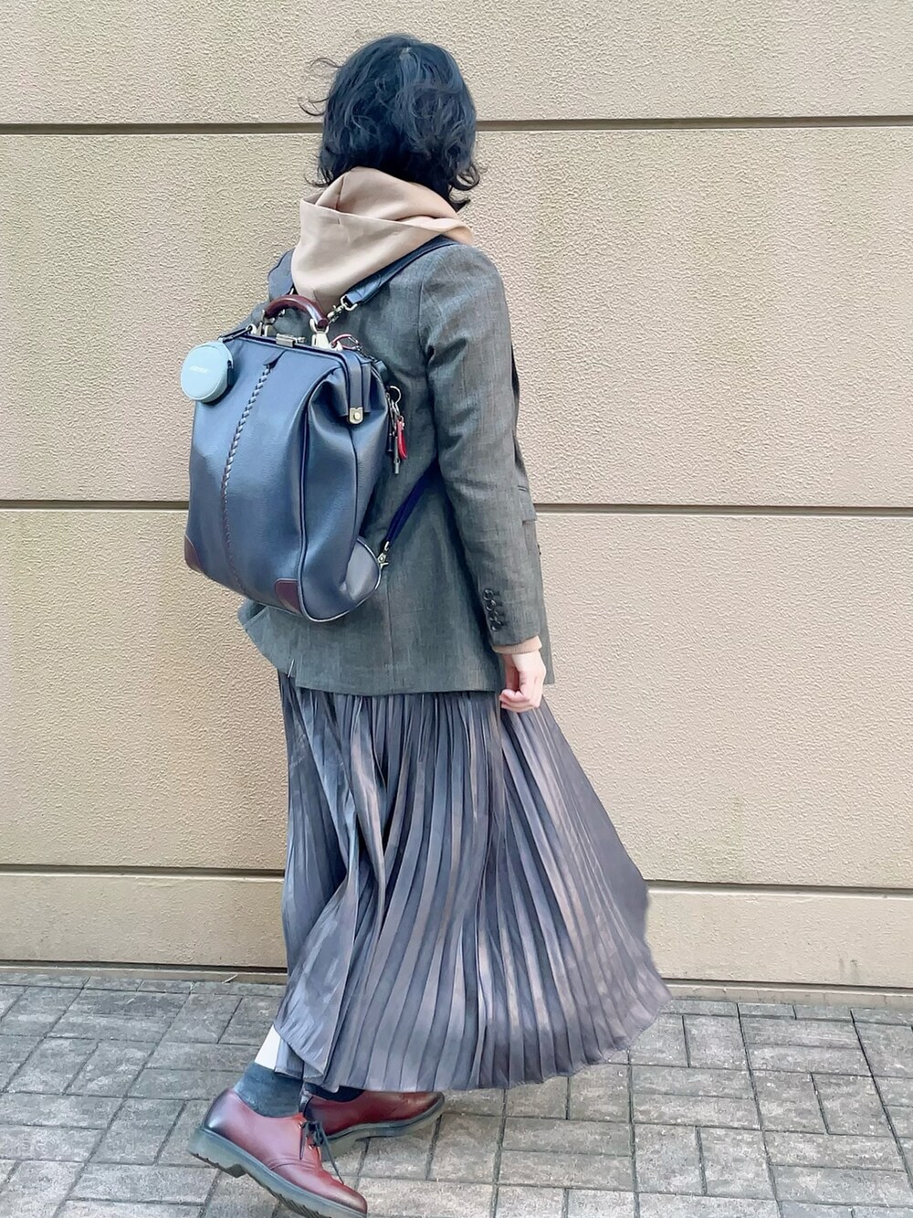 ブラウン系のブルゾン、イエロー系のパーカー、グレー系のスカートを着用したレディースの冬コーディネートの2枚目の写真