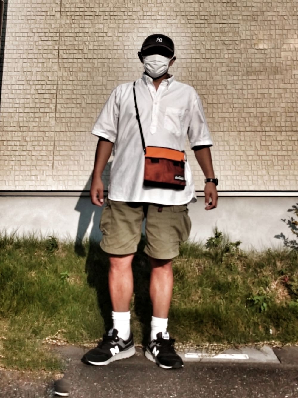 グリーン系のカーゴパンツ、ホワイト系のシャツ/ブラウス、オレンジ系のショルダーバッグを着用したメンズの秋コーディネートの2枚目の写真