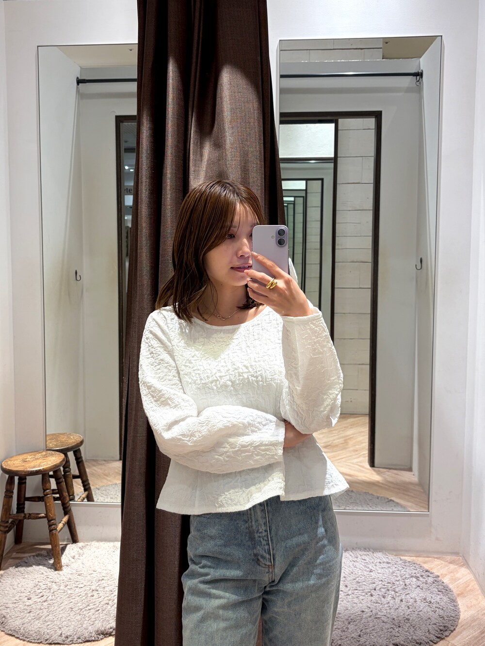 ブルー系のデニムパンツ、ブラック系のパンプス、ベージュ系のショルダーバッグを着用したレディースの春コーディネートの4枚目の写真