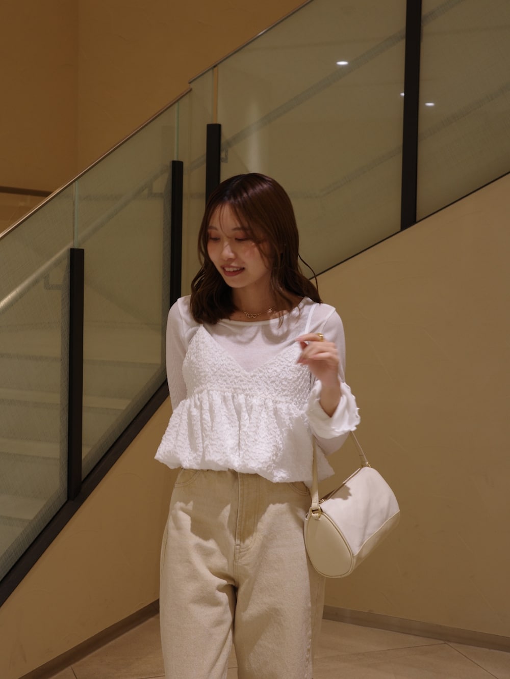 ブラック系のパンプス、ホワイト系のシャツ/ブラウス、ベージュ系のショルダーバッグを着用したレディースの春コーディネートの3枚目の写真