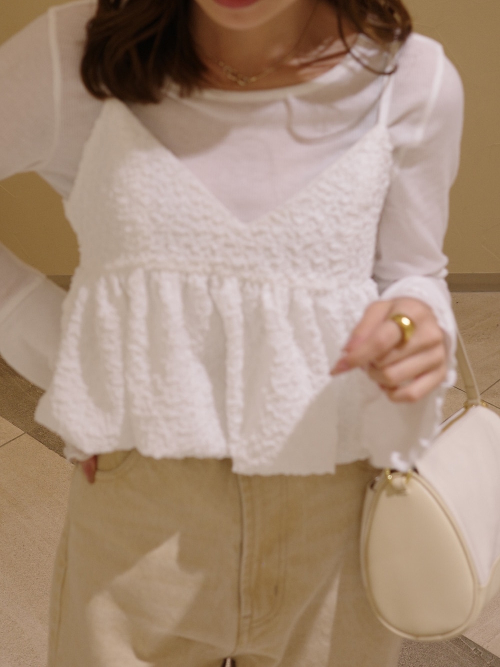 ブラック系のパンプス、ホワイト系のシャツ/ブラウス、ベージュ系のショルダーバッグを着用したレディースの春コーディネートの4枚目の写真