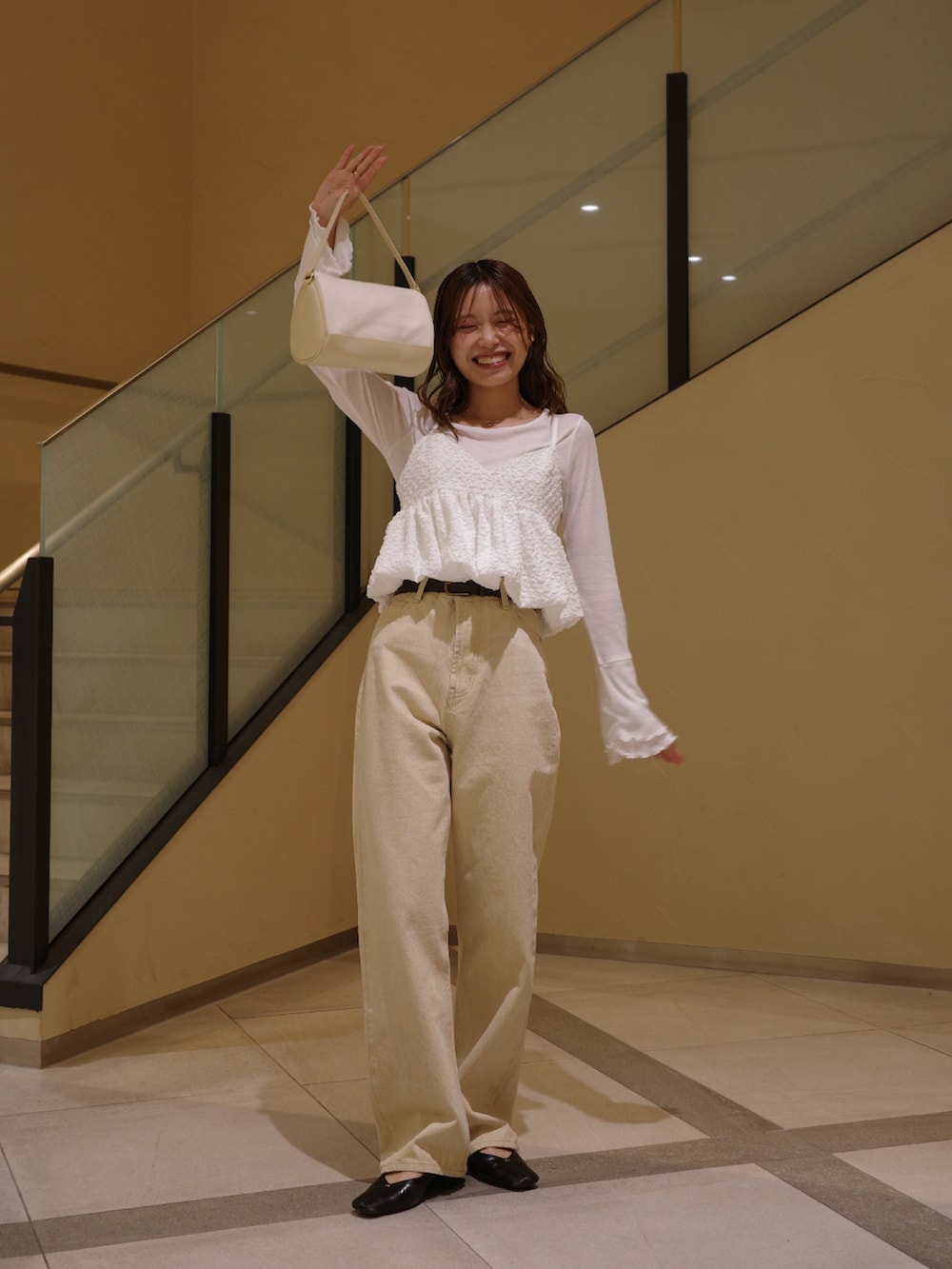 ブラック系のパンプス、ホワイト系のシャツ/ブラウス、ベージュ系のショルダーバッグを着用したレディースの春コーディネートの6枚目の写真