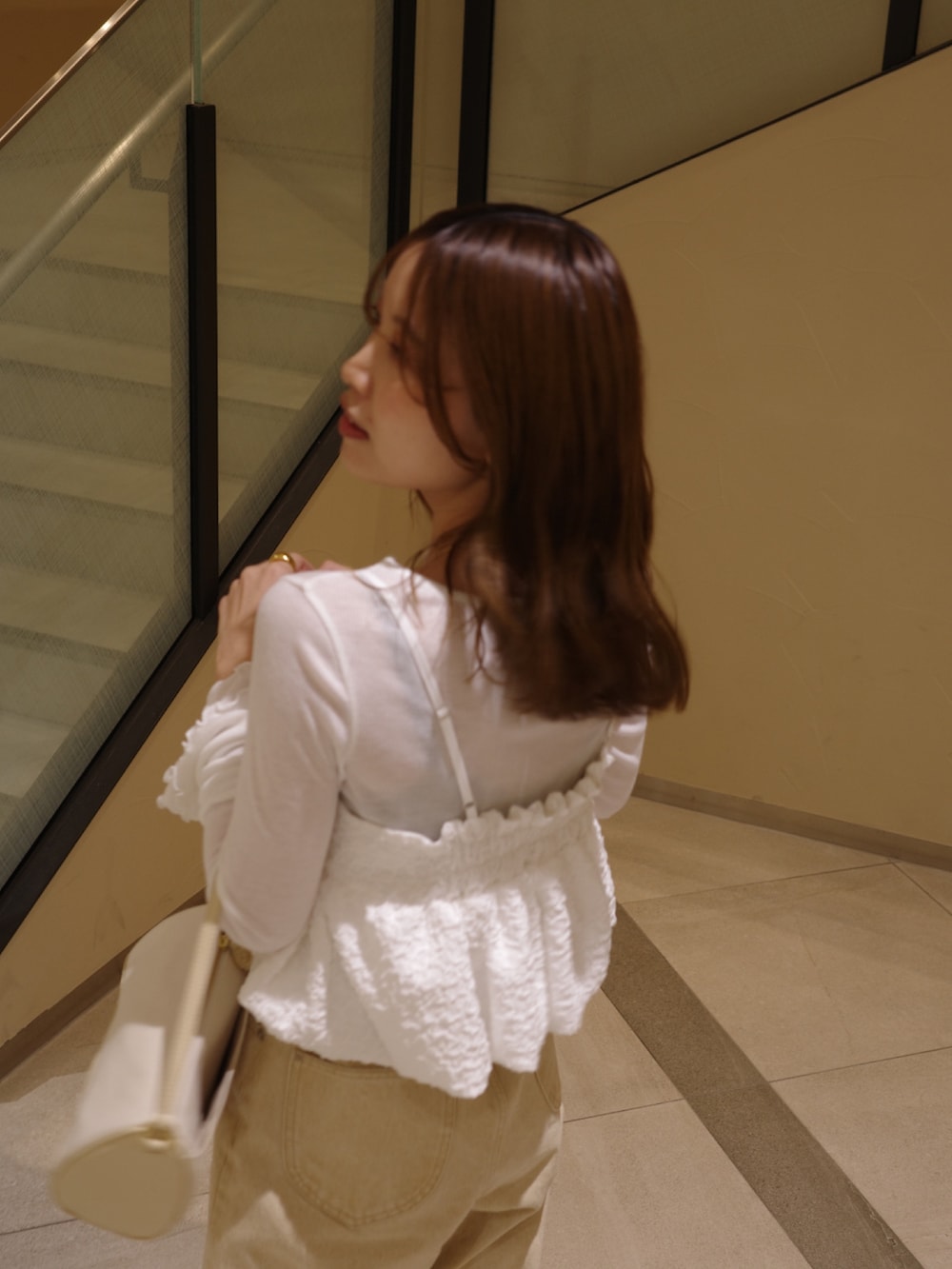 ブラック系のパンプス、ホワイト系のシャツ/ブラウス、ベージュ系のショルダーバッグを着用したレディースの春コーディネートの5枚目の写真