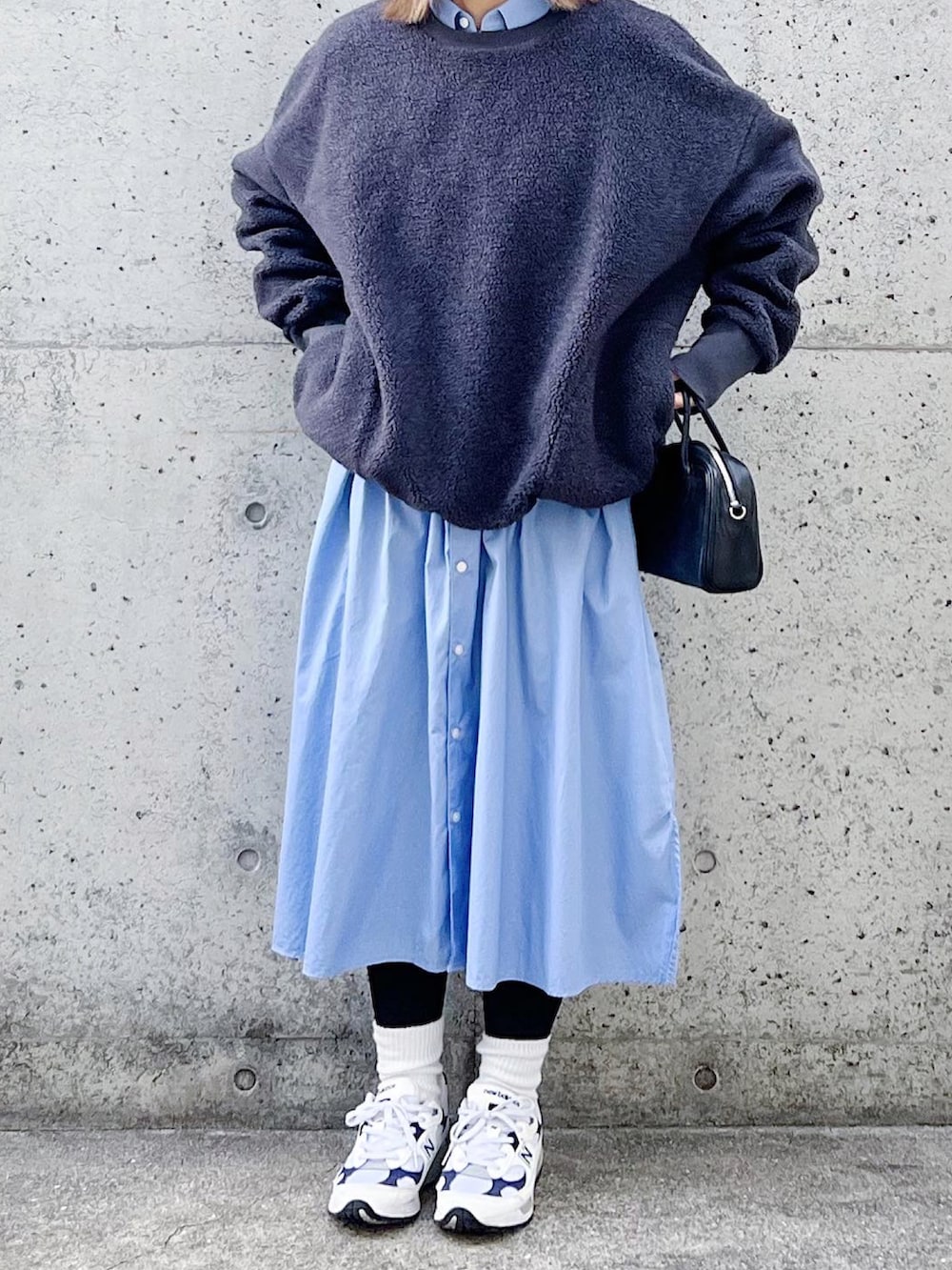 グレー系のトップス、ブルー系のシャツワンピース、ホワイト系のスニーカーを着用したレディースの冬コーディネートの2枚目の写真