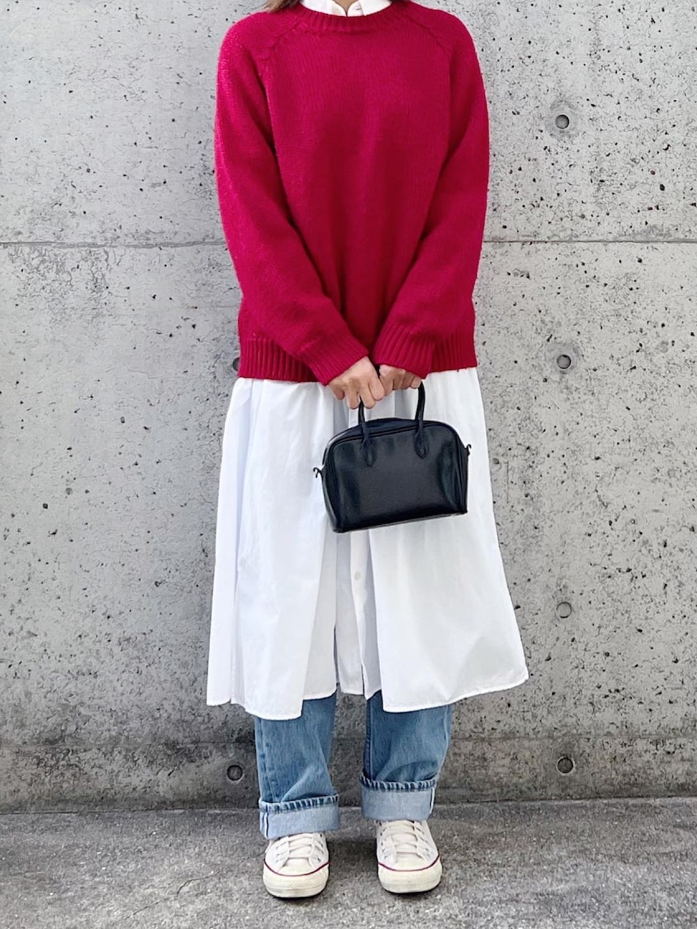 レッド系のニット/セーター、ホワイト系のシャツワンピース、ホワイト系のスニーカーを着用したレディースの冬コーディネートの2枚目の写真