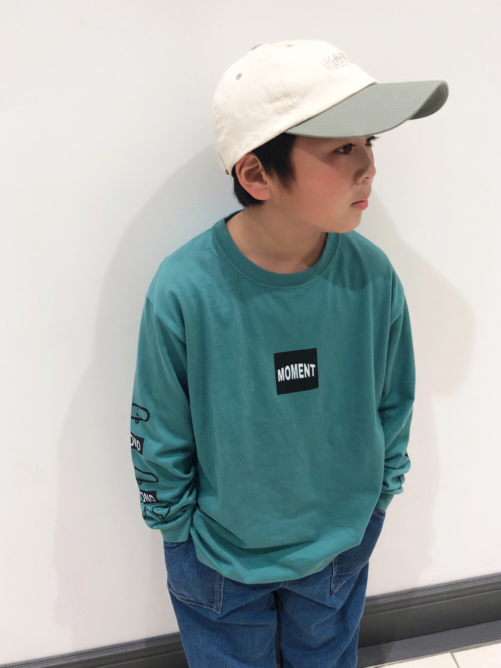 グリーン系のTシャツ/カットソー、ブルー系のデニムパンツ、イエロー系のスニーカーを着用したキッズの春コーディネートの3枚目の写真