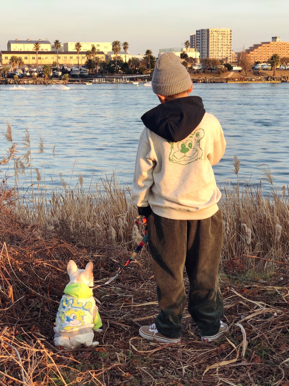 ブラック系のモッズコート、ホワイト系のパーカー、グリーン系のその他パンツを着用したキッズの冬コーディネートの3枚目の写真