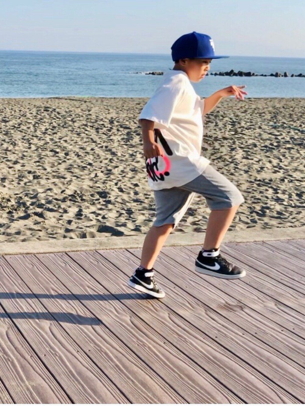 ホワイト系のTシャツ/カットソー、グレー系のその他パンツ、ブラック系のスニーカーを着用したキッズの夏コーディネートの3枚目の写真
