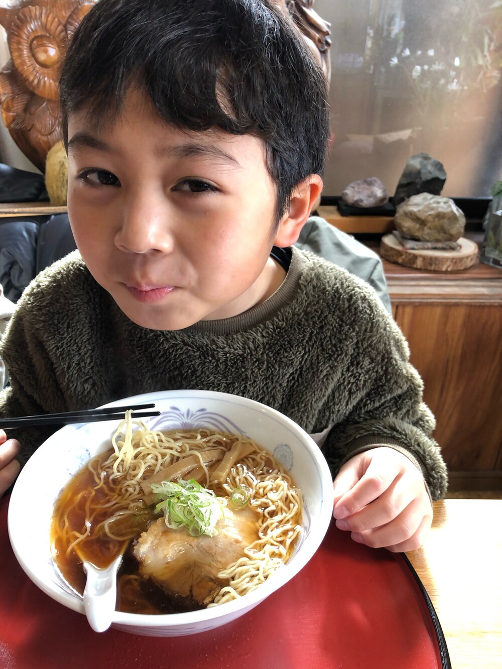 グリーン系のダウンジャケット/コート、グリーン系のスウェット、ブラウン系のその他パンツを着用したキッズの冬コーディネートの2枚目の写真
