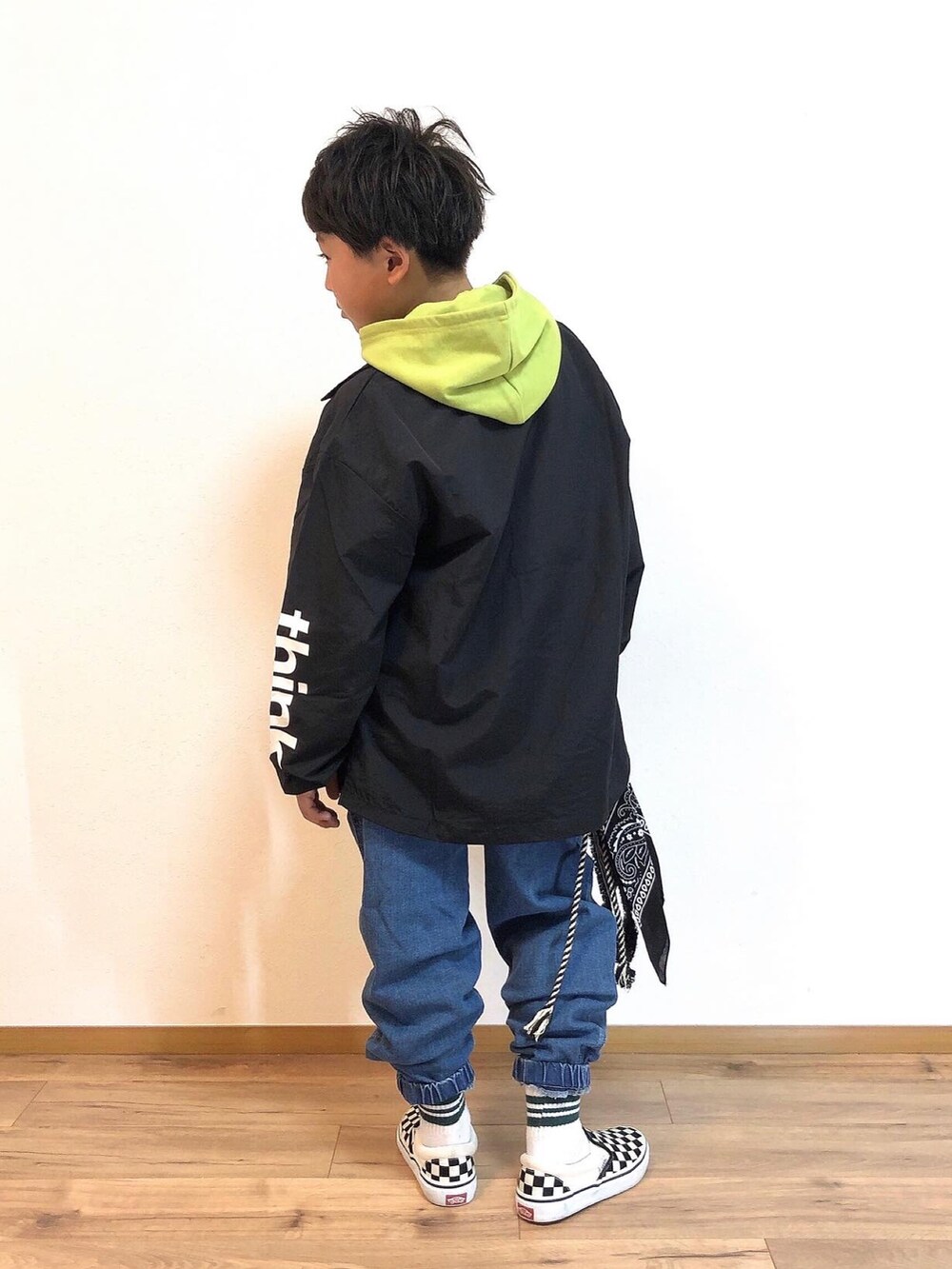 ブラック系のノーカラージャケット、グリーン系のパーカー、ブルー系のデニムパンツを着用したキッズの春コーディネートの2枚目の写真