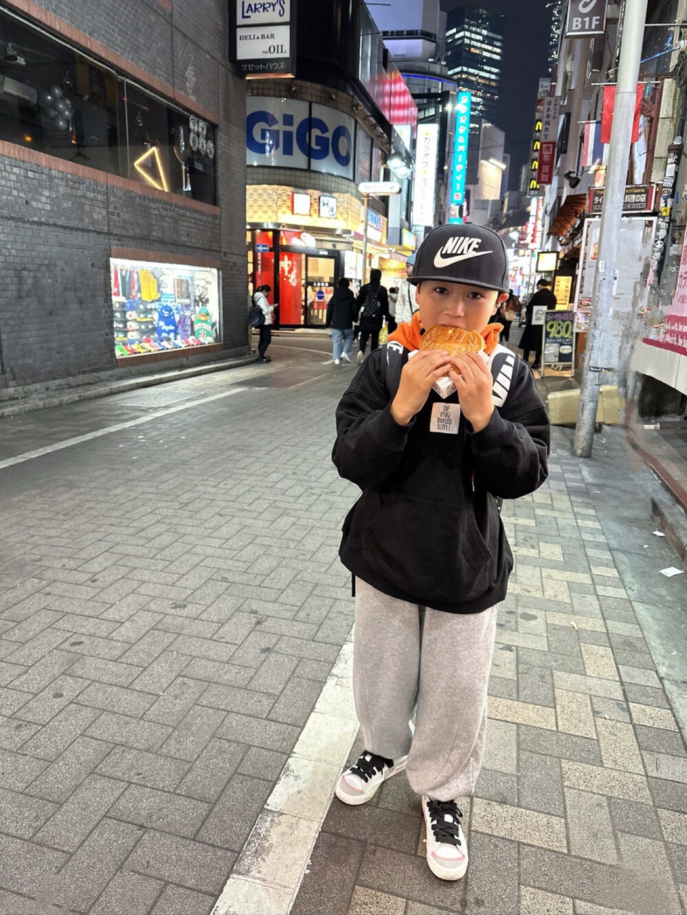 ブラック系のスタジャン、グレー系のパーカー、ブラック系のバックパック/リュックを着用したキッズの冬コーディネートの4枚目の写真
