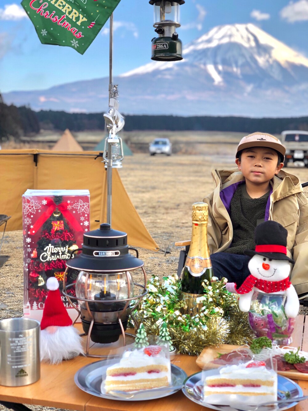 ベージュ系のマウンテンパーカー、ブルー系のパンツ、グリーン系のトップスを着用したキッズの冬コーディネートの2枚目の写真