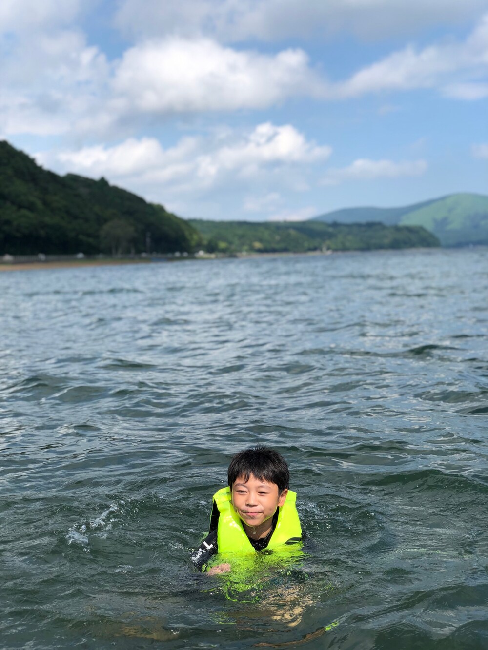 グリーン系のTシャツ/カットソー、ホワイト系のパンツ、ブラック系のサンダルを着用したキッズの夏コーディネートの4枚目の写真