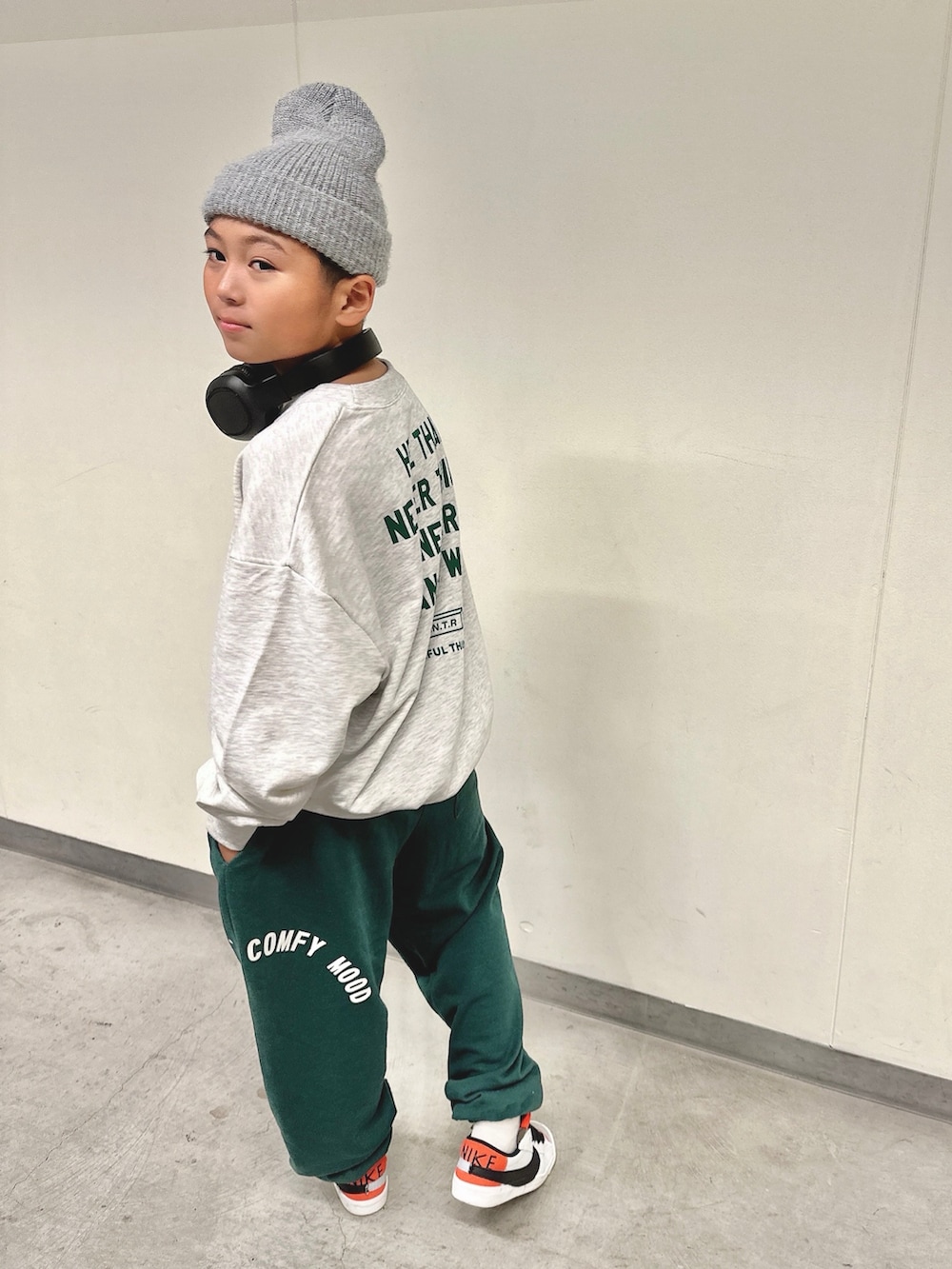 グレー系のスウェット、グリーン系のスウェットパンツ、ホワイト系のスニーカーを着用したキッズの冬コーディネートの3枚目の写真