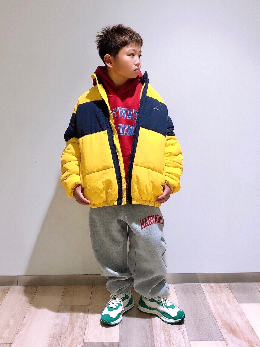 レッド系のパーカー、イエロー系のブルゾン、グレー系のスウェットパンツを着用したキッズの冬コーディネートの2枚目の写真