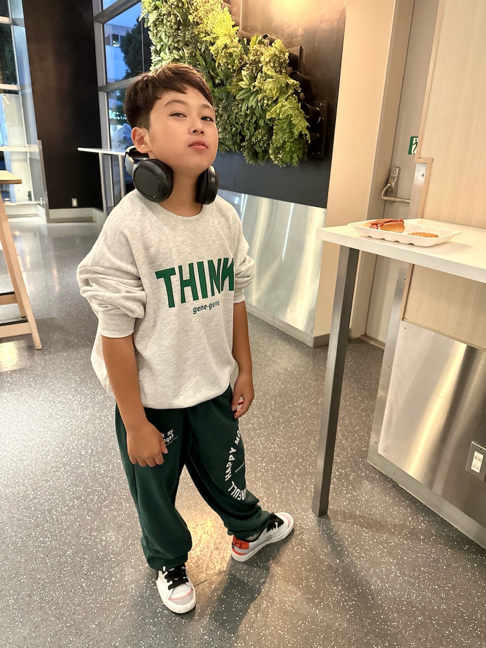 グレー系のスウェット、グリーン系のスウェットパンツ、ホワイト系のスニーカーを着用したキッズの冬コーディネートの4枚目の写真