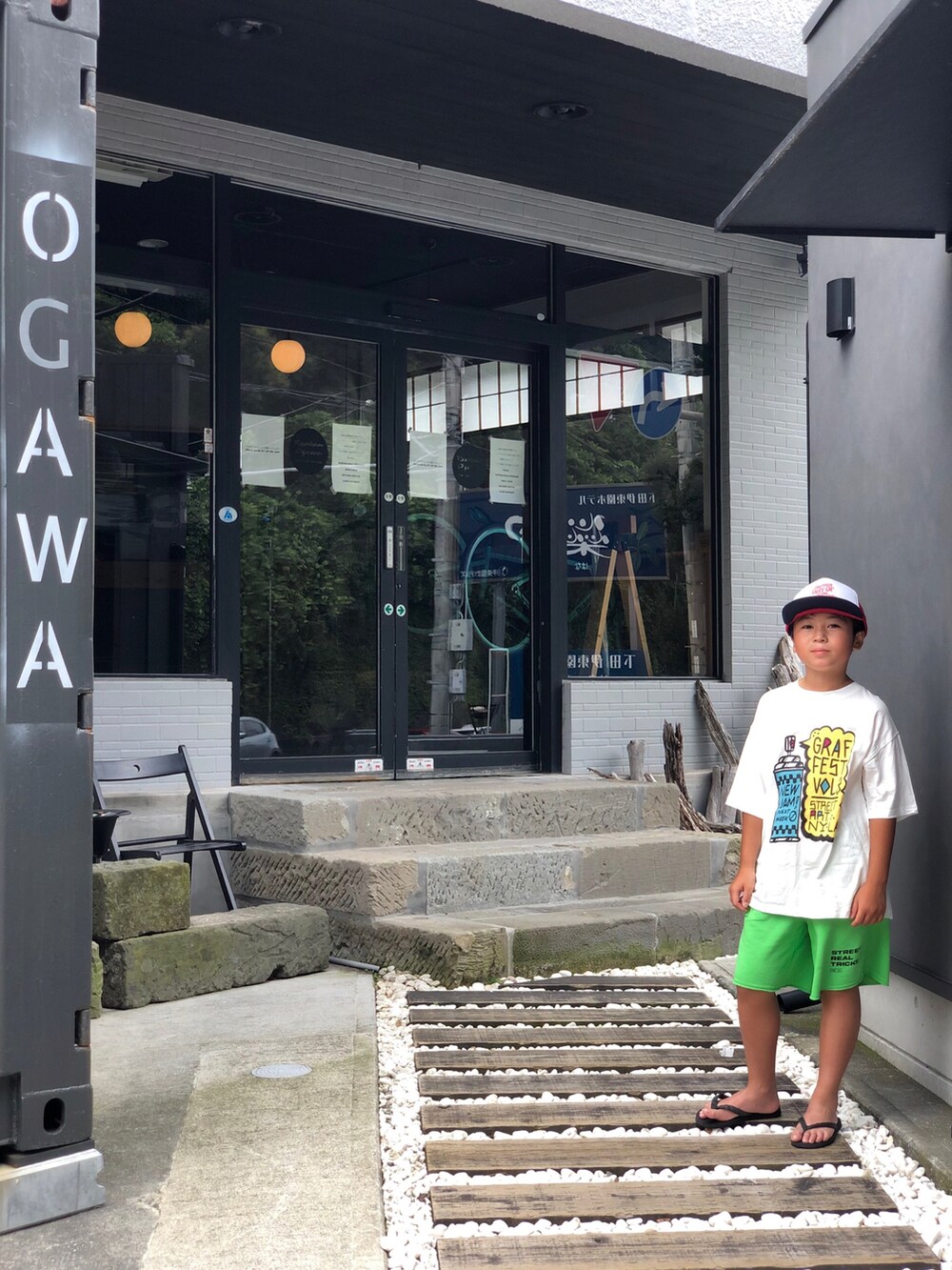 ホワイト系のTシャツ/カットソー、グリーン系のパンツ、ブラック系のサンダルを着用したキッズの夏コーディネートの2枚目の写真