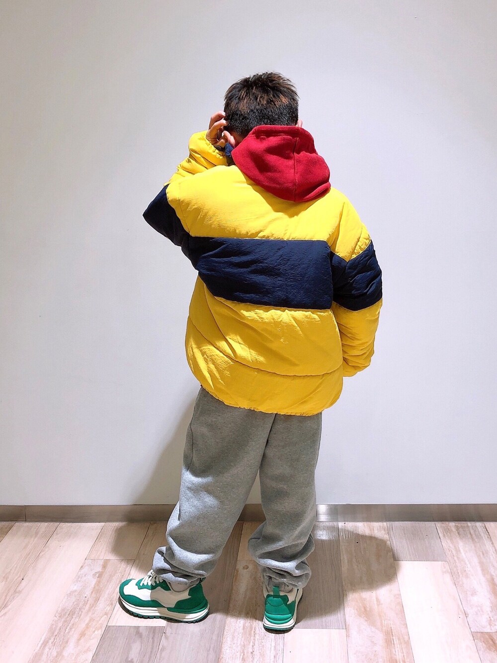 レッド系のパーカー、イエロー系のブルゾン、グレー系のスウェットパンツを着用したキッズの冬コーディネートの3枚目の写真