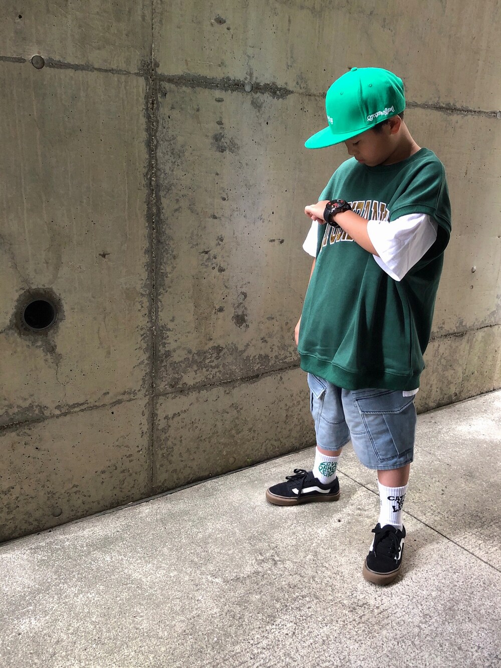 グリーン系のベスト、ホワイト系のTシャツ/カットソー、ブルー系のスウェットパンツを着用したキッズの夏コーディネートの3枚目の写真