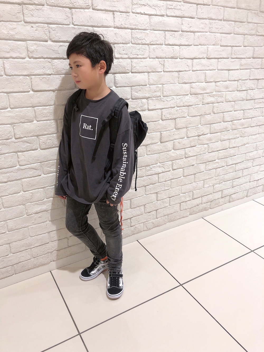 グレー系のTシャツ/カットソー、ブラック系のデニムパンツ、ブラック系のバックパック/リュックを着用したキッズの秋コーディネートの2枚目の写真