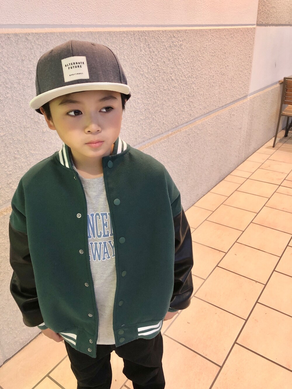 グリーン系のスタジャン、グレー系のTシャツ/カットソー、ブラック系のパンツを着用したキッズの冬コーディネートの4枚目の写真