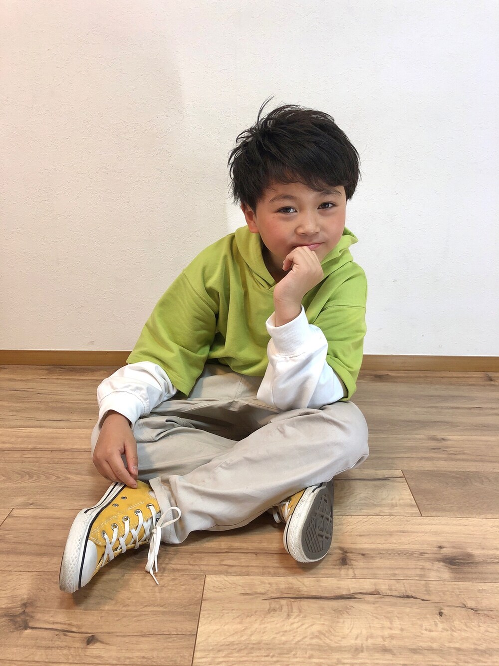 グリーン系のパーカー、ベージュ系のその他パンツ、イエロー系のスニーカーを着用したキッズの春コーディネートの2枚目の写真
