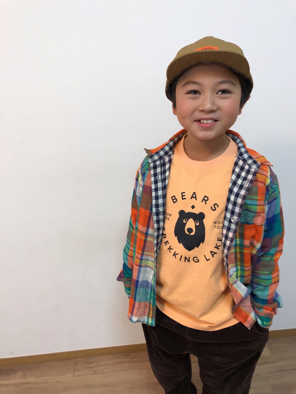 オレンジ系のシャツ/ブラウス、ブラウン系のその他パンツ、ベージュ系のスニーカーを着用したキッズの冬コーディネートの3枚目の写真