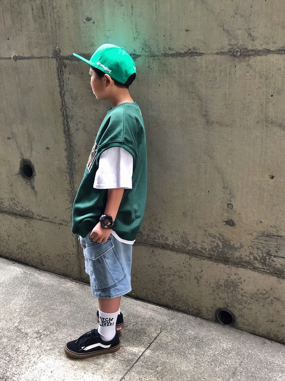 グリーン系のベスト、ホワイト系のTシャツ/カットソー、ブルー系のスウェットパンツを着用したキッズの夏コーディネートの2枚目の写真