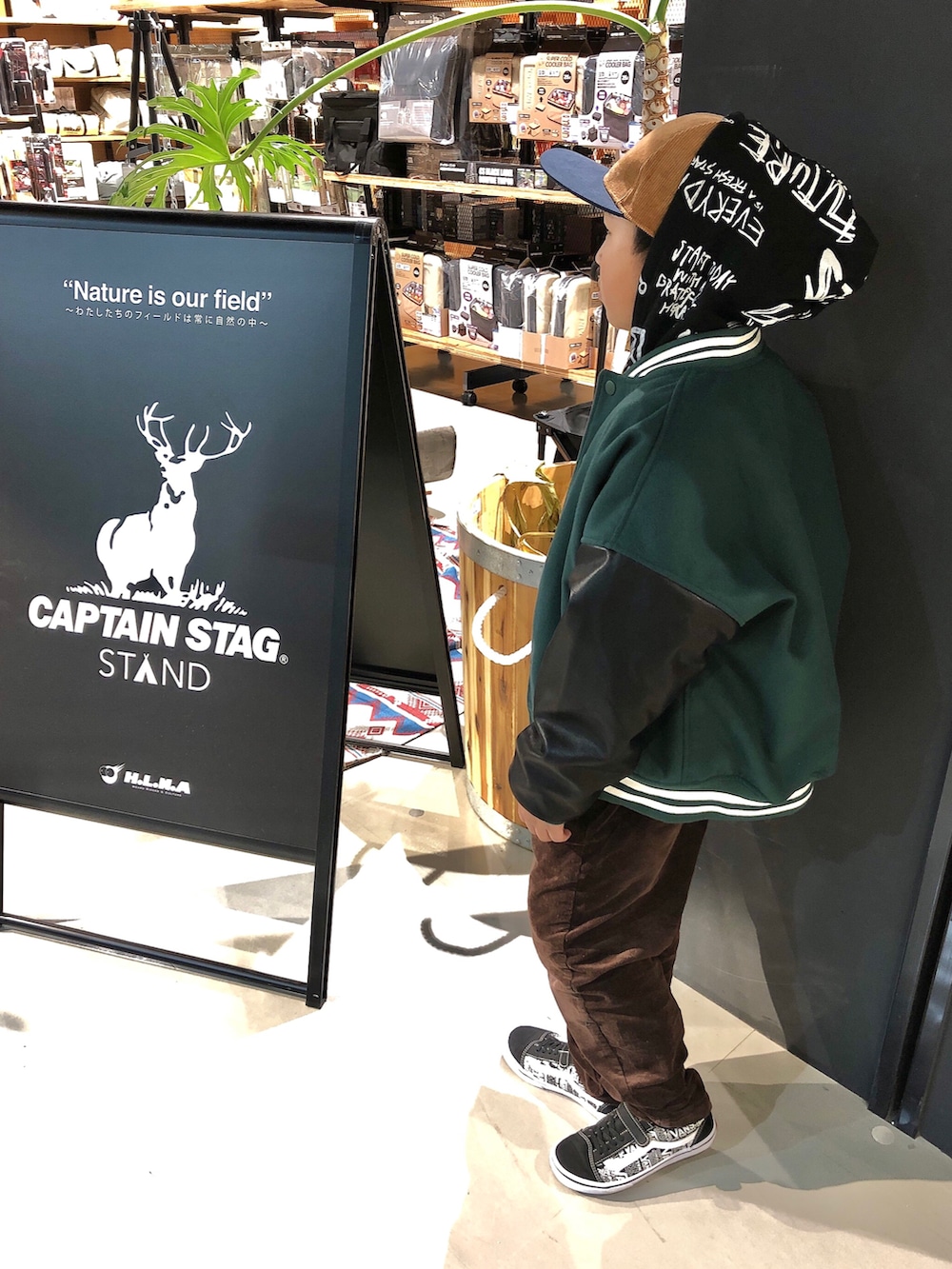 グリーン系のスタジャン、ブラック系のパーカー、ブラウン系のその他パンツを着用したキッズの冬コーディネートの3枚目の写真