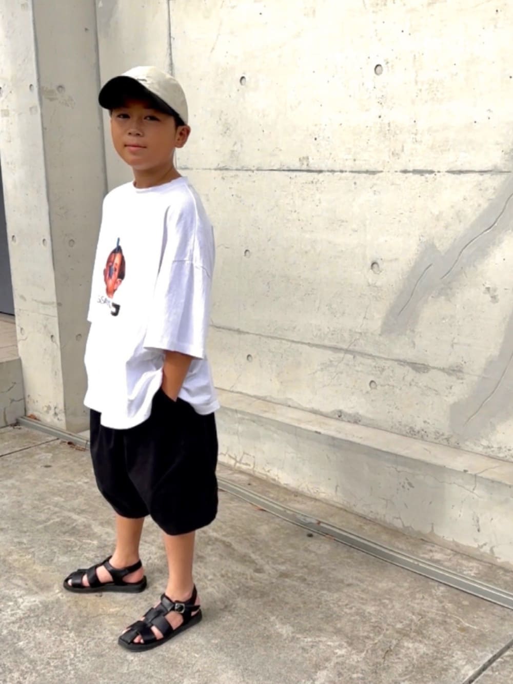 ホワイト系のTシャツ/カットソー、ブラック系のその他パンツ、ブラック系のサンダルを着用したキッズの夏コーディネートの2枚目の写真