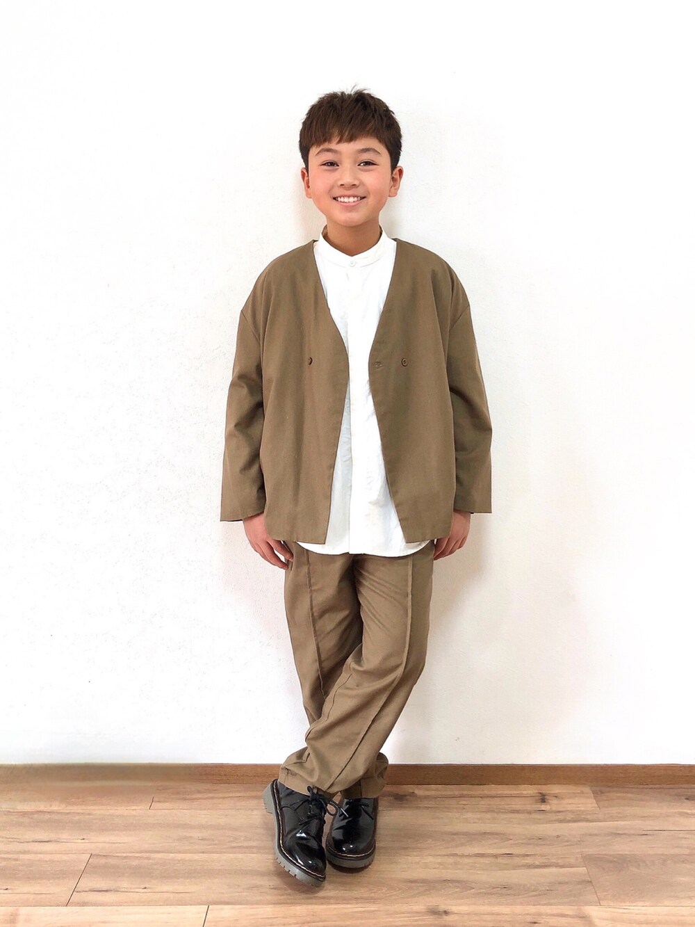 ブラウン系のフォーマルスーツ/小物、ホワイト系のシャツ/ブラウス、ブラック系のドレスシューズを着用したキッズの春コーディネートの2枚目の写真